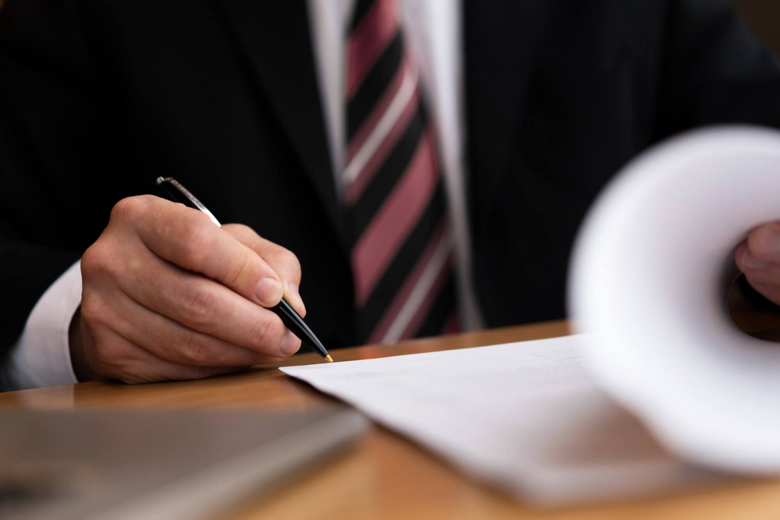 Pessoa assinando documentos.