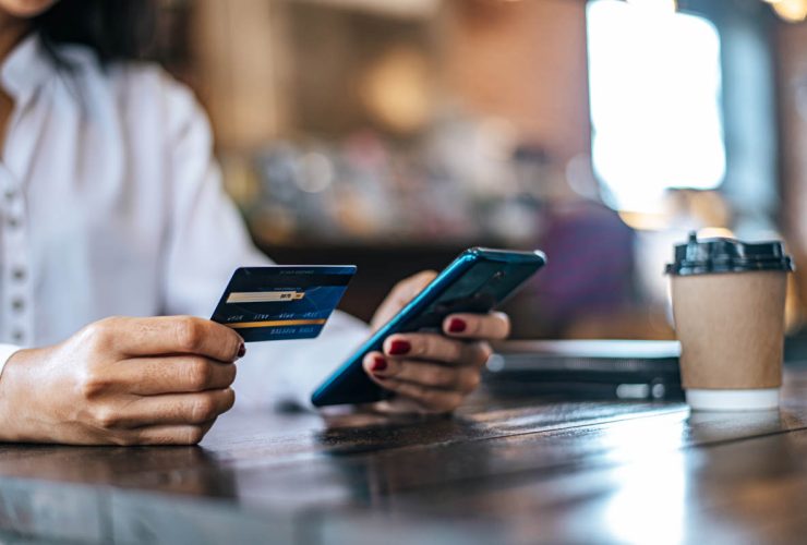 Pessoa pagando com cartão de débito em uma página de checkout acessada por link de pagamento no celular.