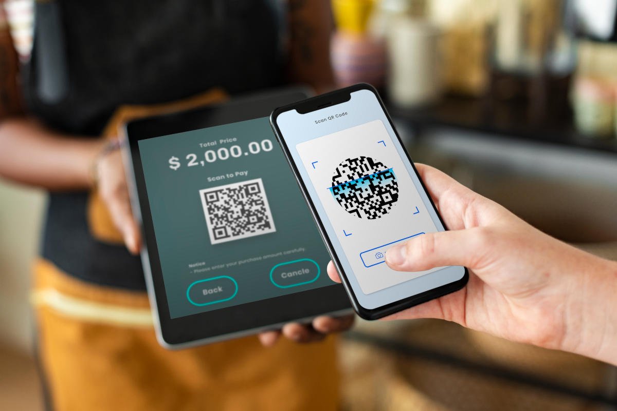 Pessoa realizando um pagamento por Pix ao escanear um código QR com o smartphone.