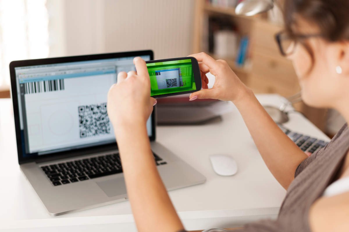 Pessoa pagando uma conta ao escanear um código QR com o celular.